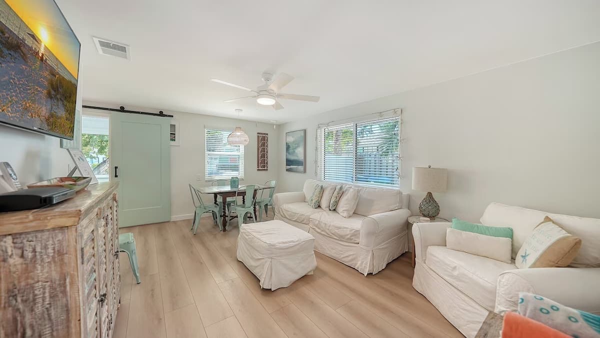 Living room with slipcovered sofas, looking toward the dining table
