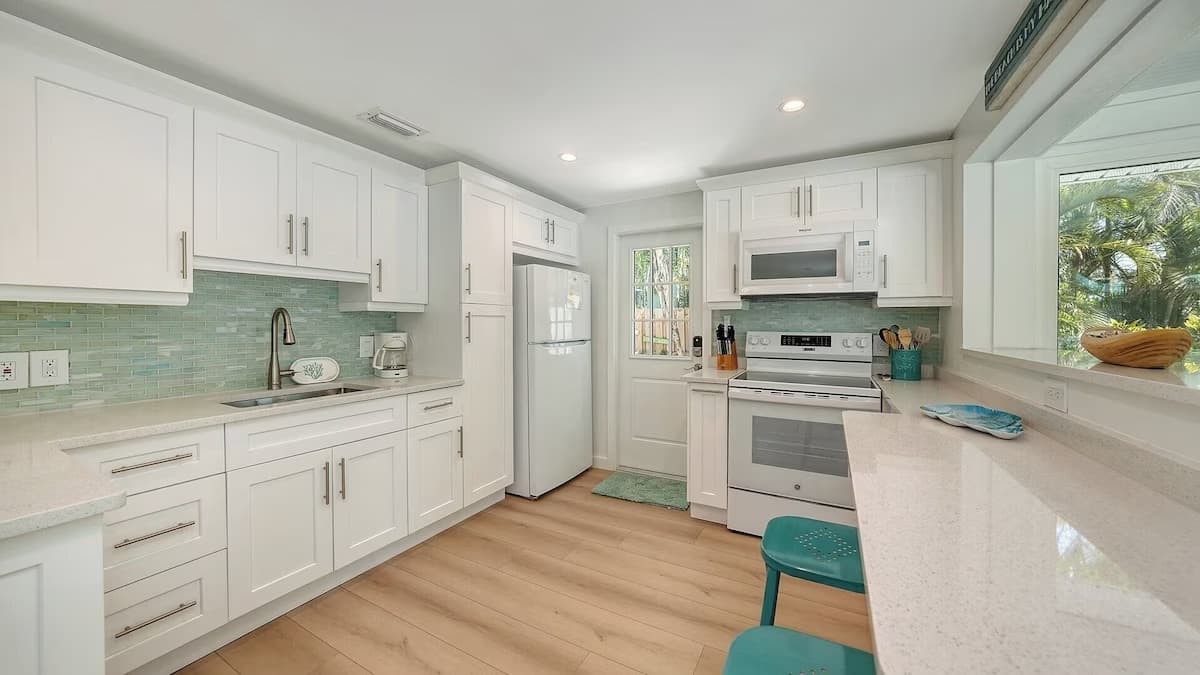 Remodeled kitchen with white cabinets and a breakfast bar